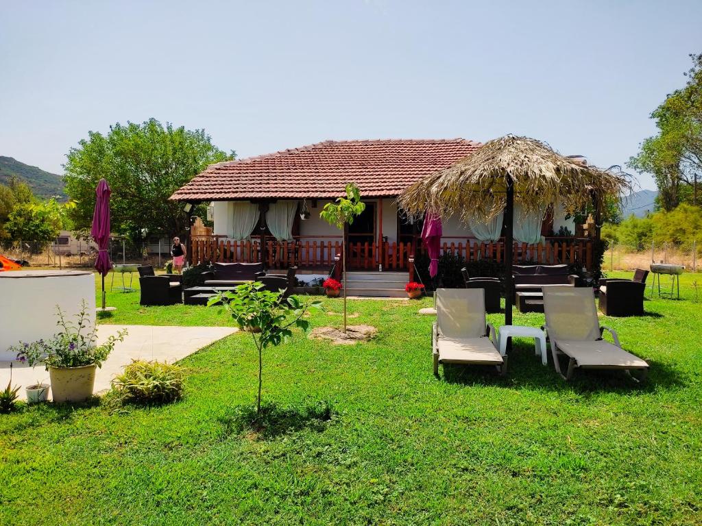 RODAVGI property overview with lush green garden, sun loungers, and thatched umbrella